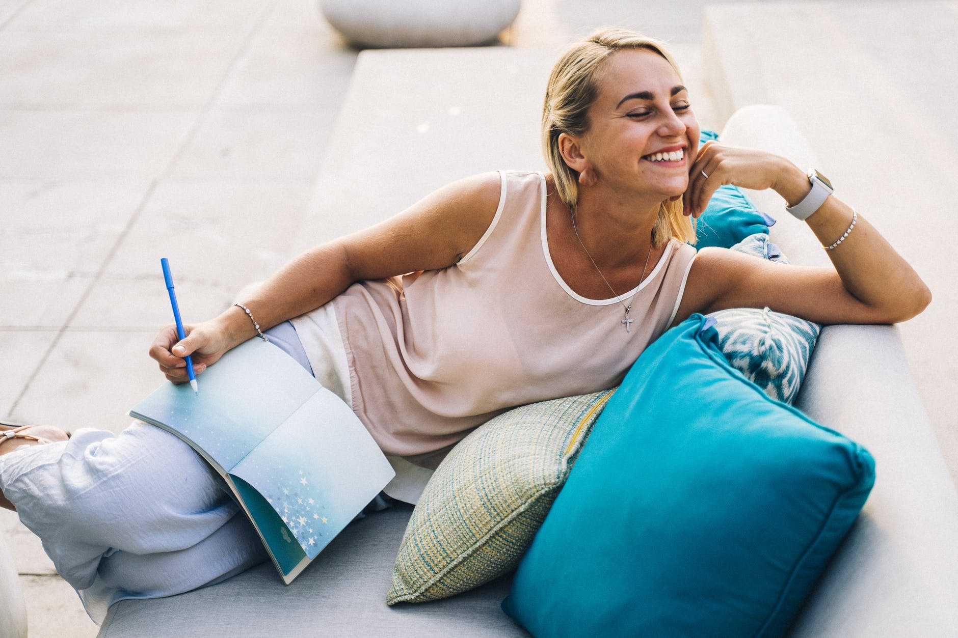 Skandinavci
a woman in a tank top smiling while sitting on a couch