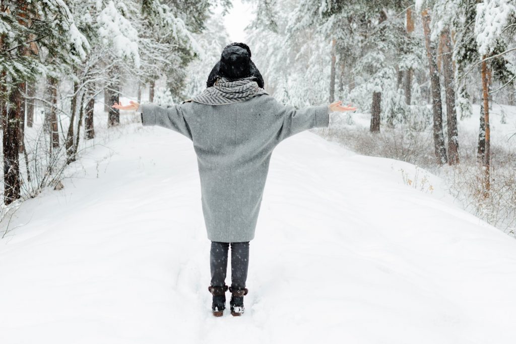 woman wearing gray topcoat during snow season