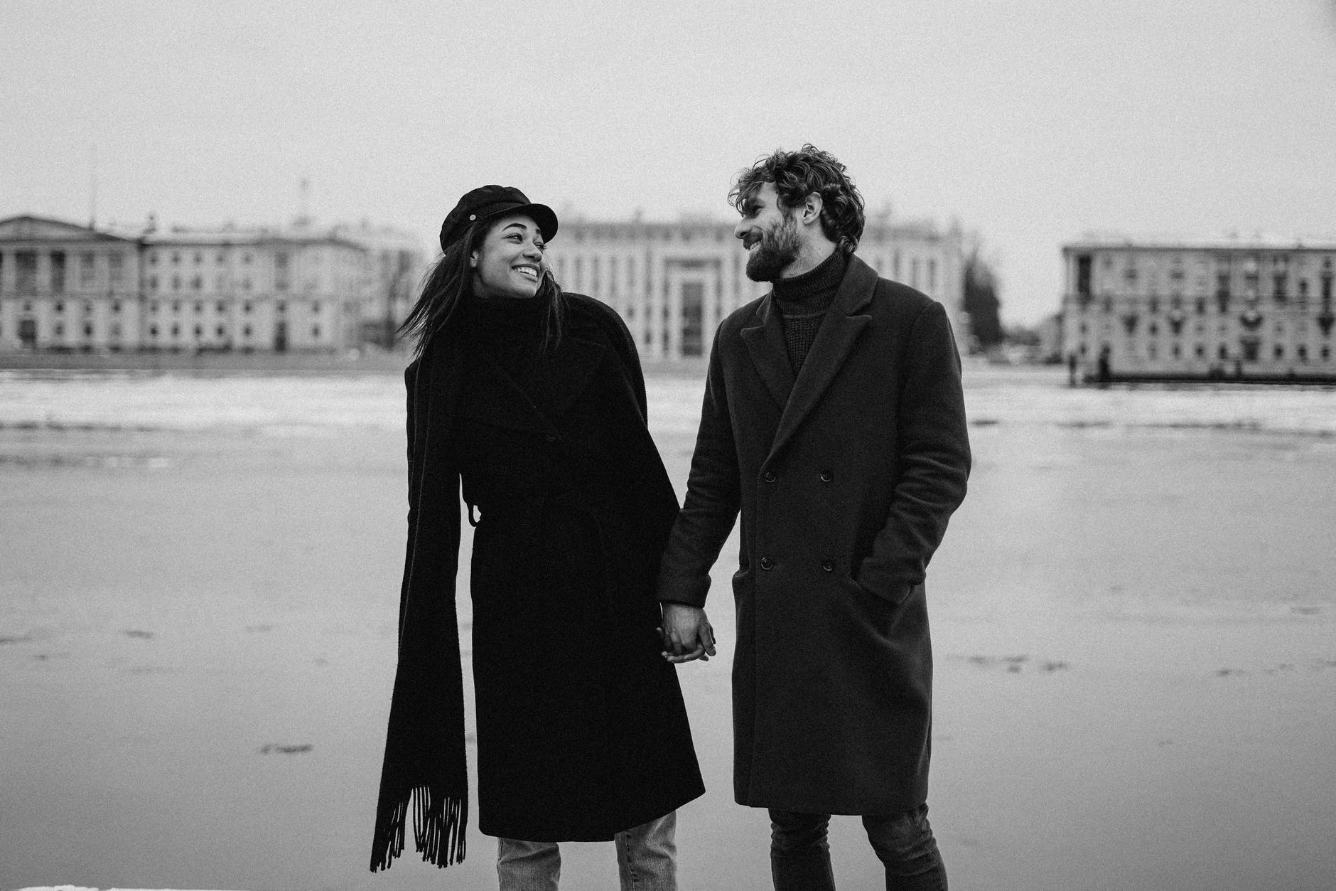 photo of couple smiling while holding hands