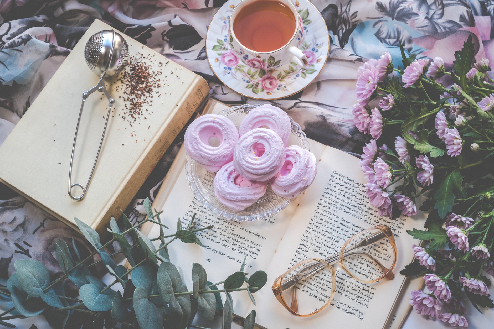 floral ceramic cup and saucer above open book