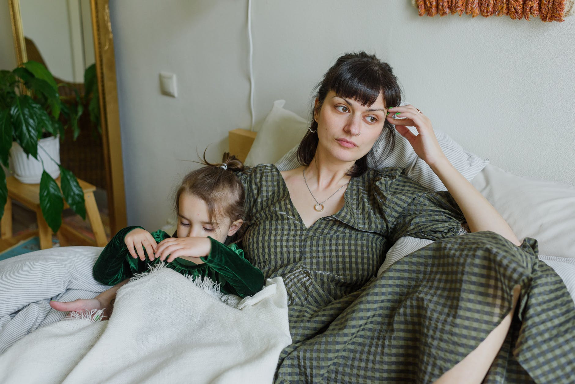 mentalno zdrava generacija, tired mother with cute daughter resting on bed in cozy room