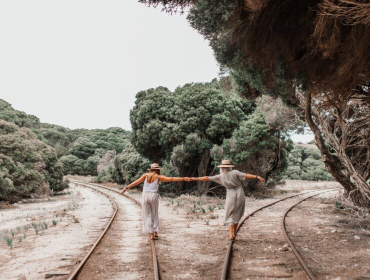 Psiholog savjetuje: pomakni se. Nisi drvo, women holding each others hand while walking on the railroad between green trees