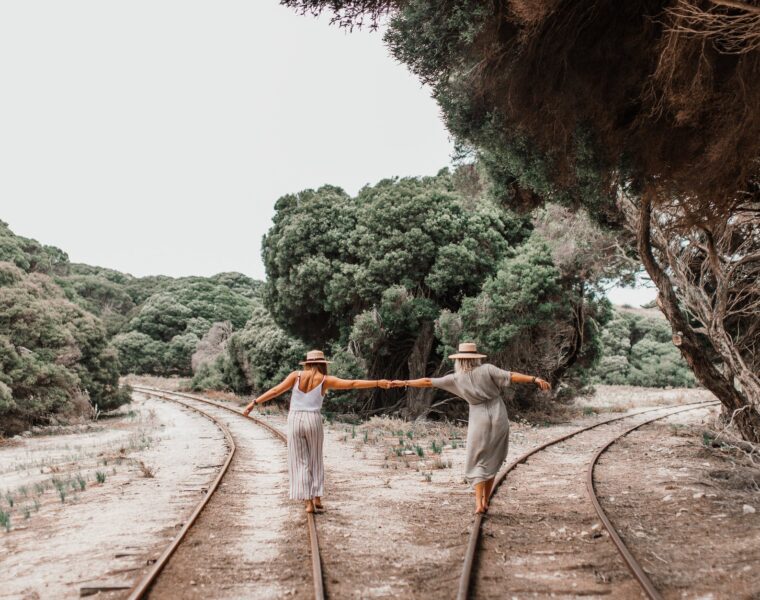 Psiholog savjetuje: pomakni se. Nisi drvo, women holding each others hand while walking on the railroad between green trees