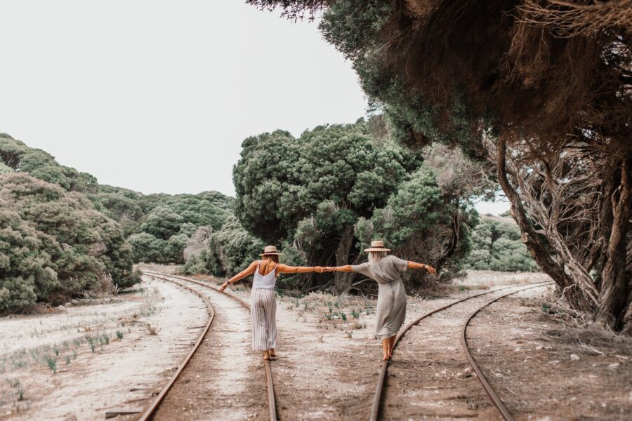 Psiholog savjetuje: pomakni se. Nisi drvo, women holding each others hand while walking on the railroad between green trees