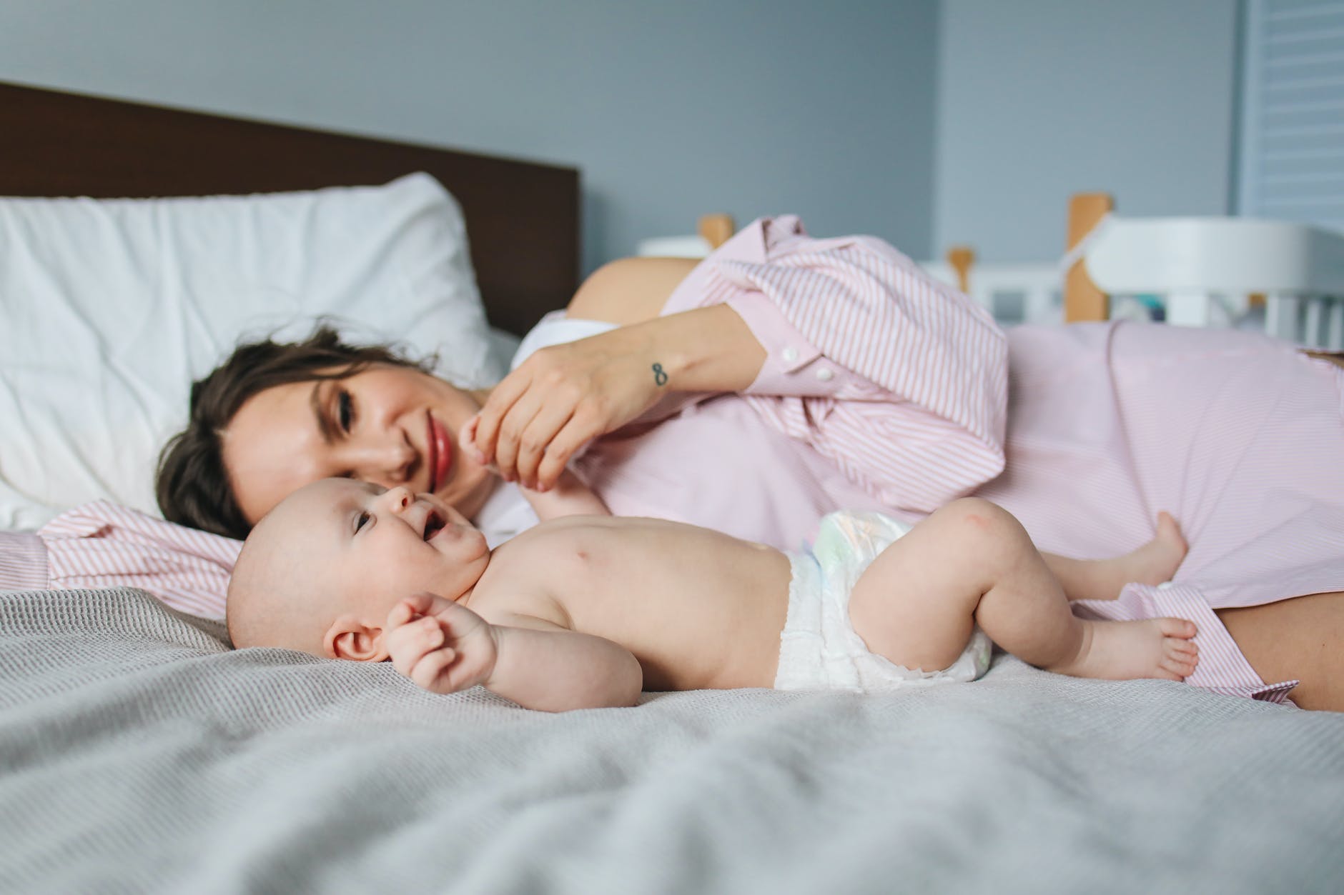 Pismo najvažnijem muškarcu u mom životu - mom sinu , woman in pink dress lying on bed next to baby in diapers
