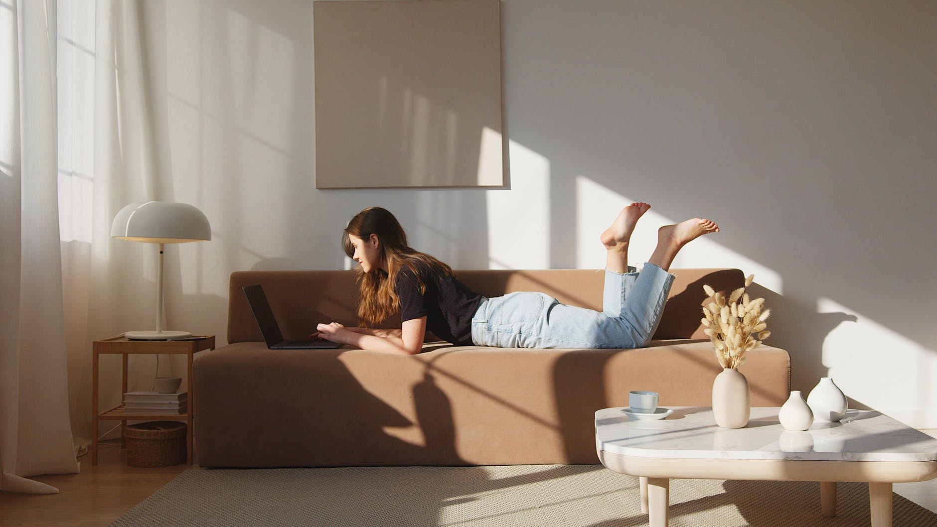 content woman resting on sofa with laptop