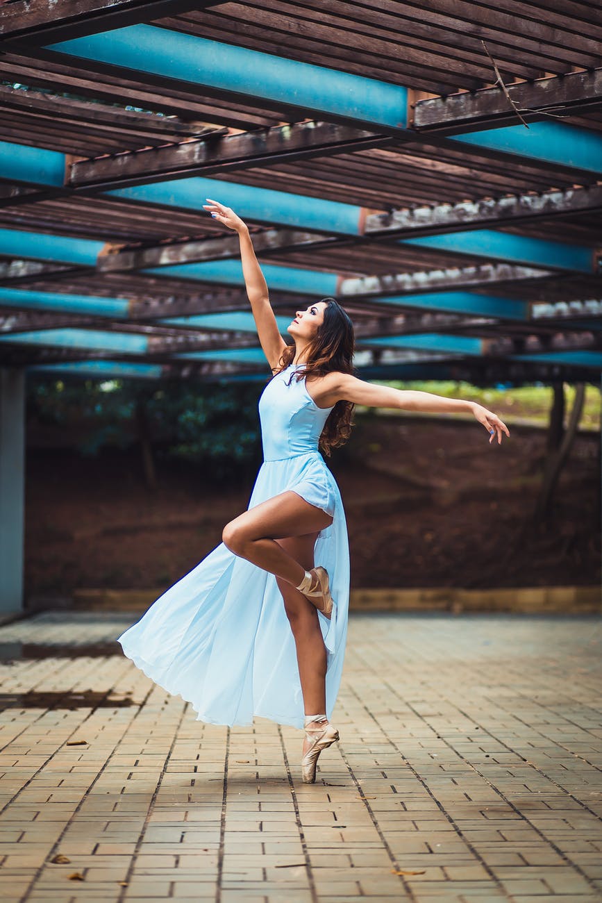 woman standing while wearing blue sleeveless dress