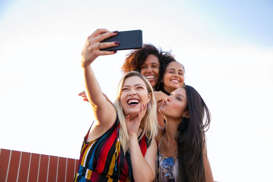Život se vrti oko vas, a ne oko muškaraca, Vjeruj u sebe, cheerful multiethnic girlfriends taking selfie on smartphone on sunny day
