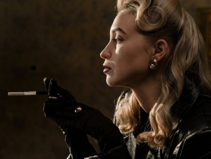ogorčenost, side view of blonde woman in black leather jacket holding a cigarette