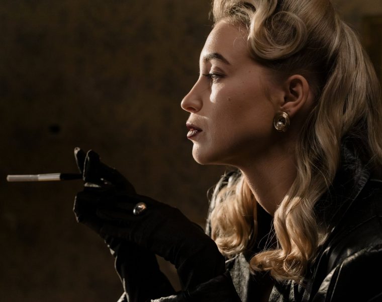 ogorčenost, side view of blonde woman in black leather jacket holding a cigarette