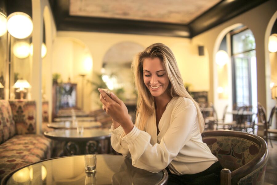 šarm, cheerful female having drink in elegant bar