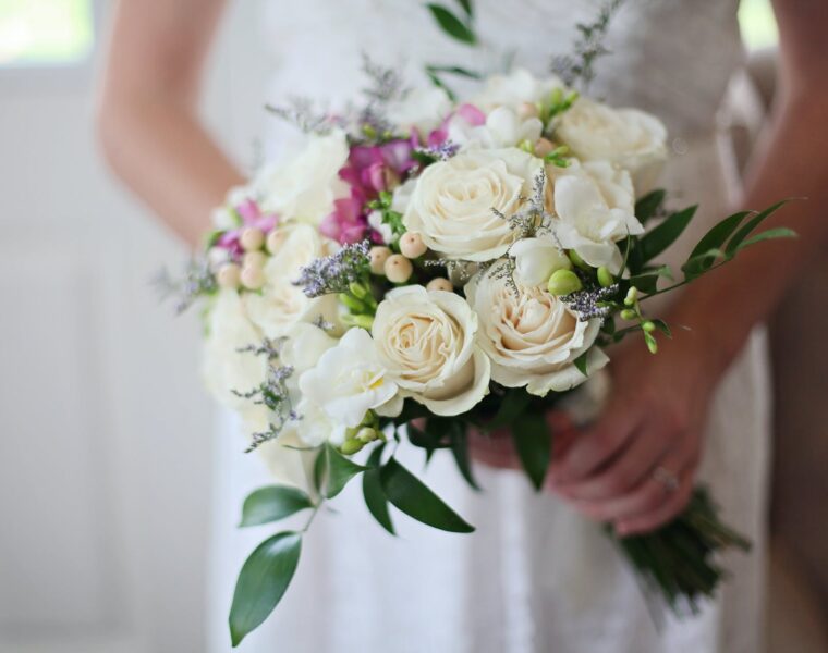 Soligamija, brides holding white bouquet of roses