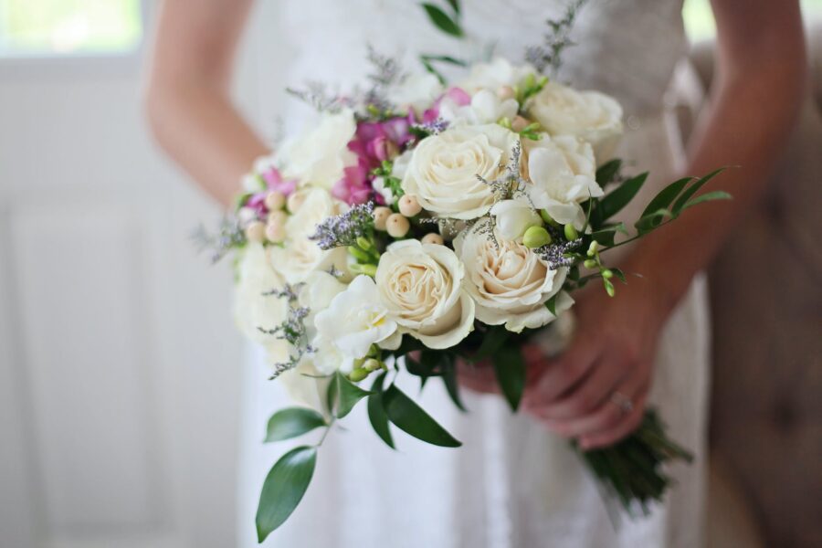 Soligamija, brides holding white bouquet of roses