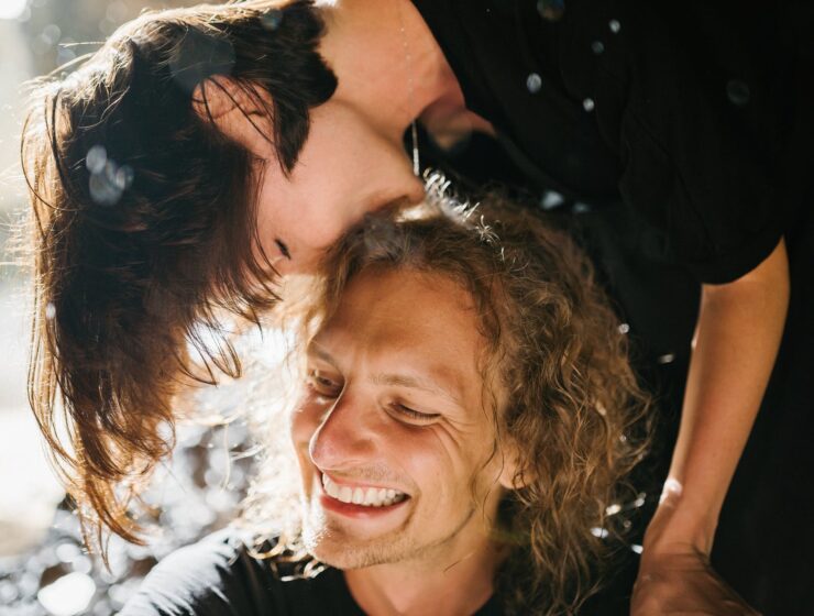Mjesečni ljubavni horoskop za ožujak, a woman in black dress kissing a man on his head