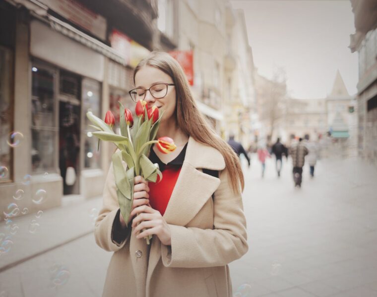 Tijekom travnja woman in beige coat holding tulips