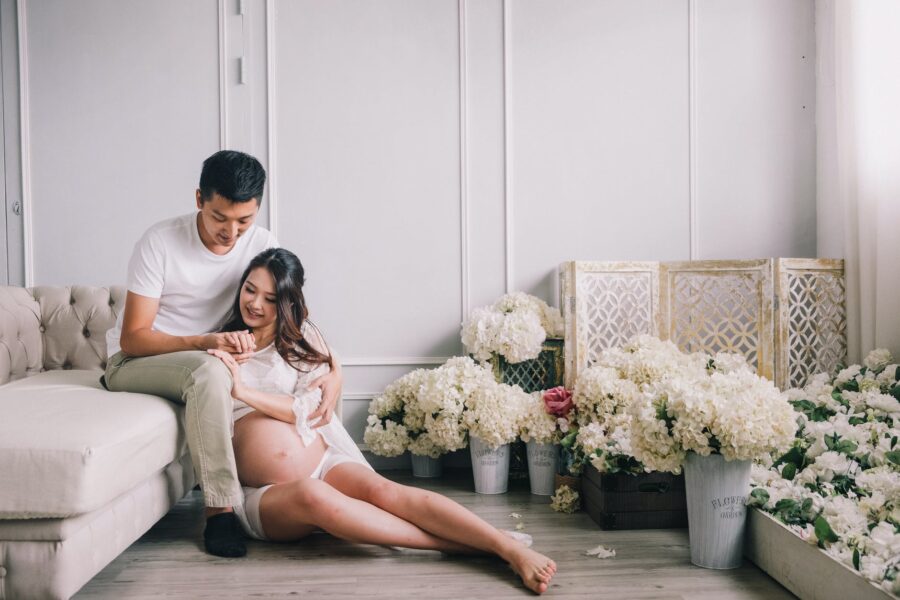 potraga za Bogom, smiling pregnant couple sitting in living room with flowers