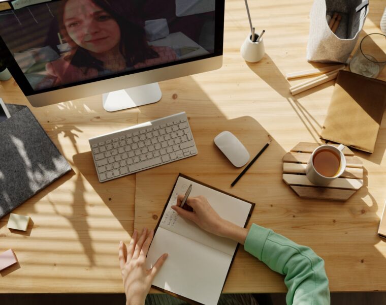 Online nastava, person writing on notebook