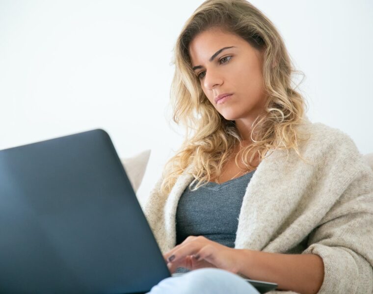 pad energije, woman sitting on sofa while using a laptop