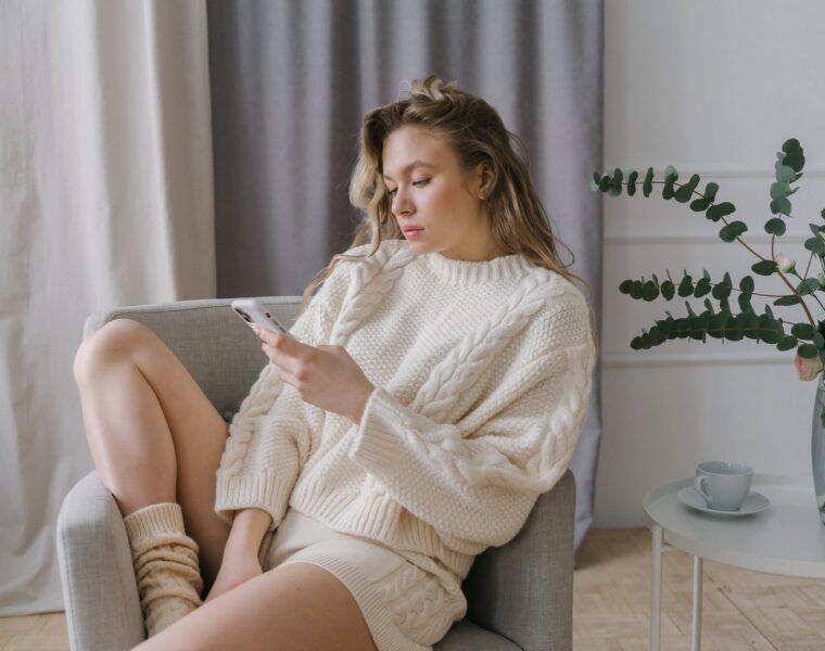 kako znakovi sabotiraju sami sebe, a woman using her smartphone while sitting