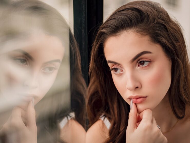 misliti na svoje potrebe, close up portrait photo of woman sitting by window looking outside