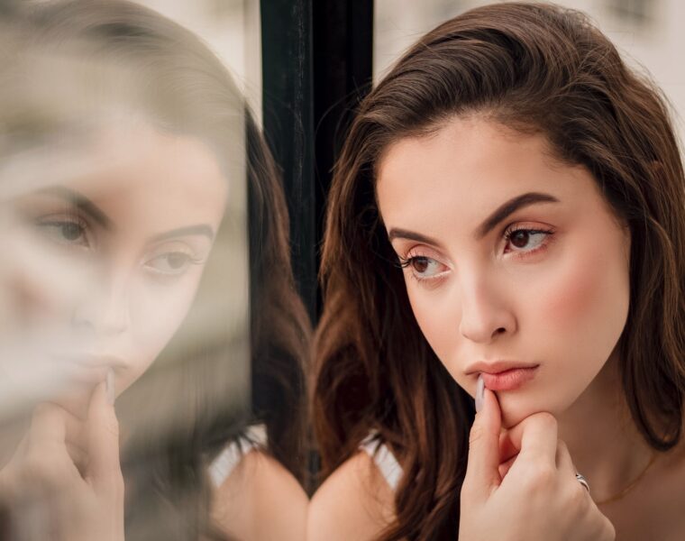 misliti na svoje potrebe, close up portrait photo of woman sitting by window looking outside