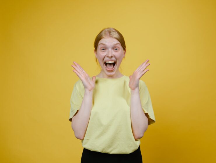 Žene koje puno galame žive duže, woman in yellow t shirt and black pants standing excited with open mouth
