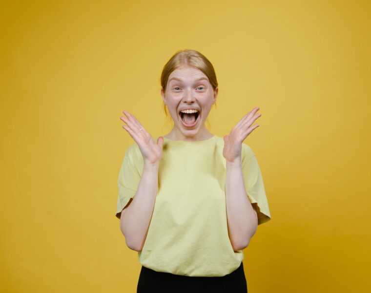 Žene koje puno galame žive duže, woman in yellow t shirt and black pants standing excited with open mouth