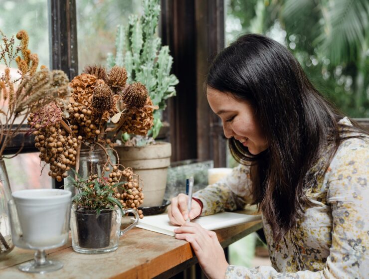 Moć neovisne žene, happy young ethnic woman writing article in cozy workplace