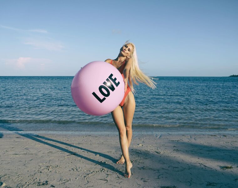 ona u rezervi Kad se zaljubiš u ideju, woman wearing orange swimsuit while holding pink inflatable beside body of water