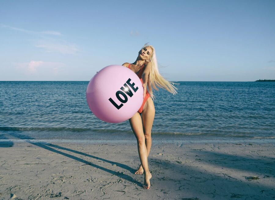 ona u rezervi Kad se zaljubiš u ideju, woman wearing orange swimsuit while holding pink inflatable beside body of water