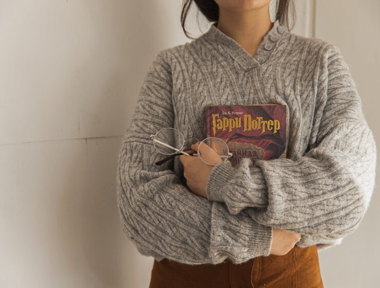 srtetnici, woman in gray sweater holding a book