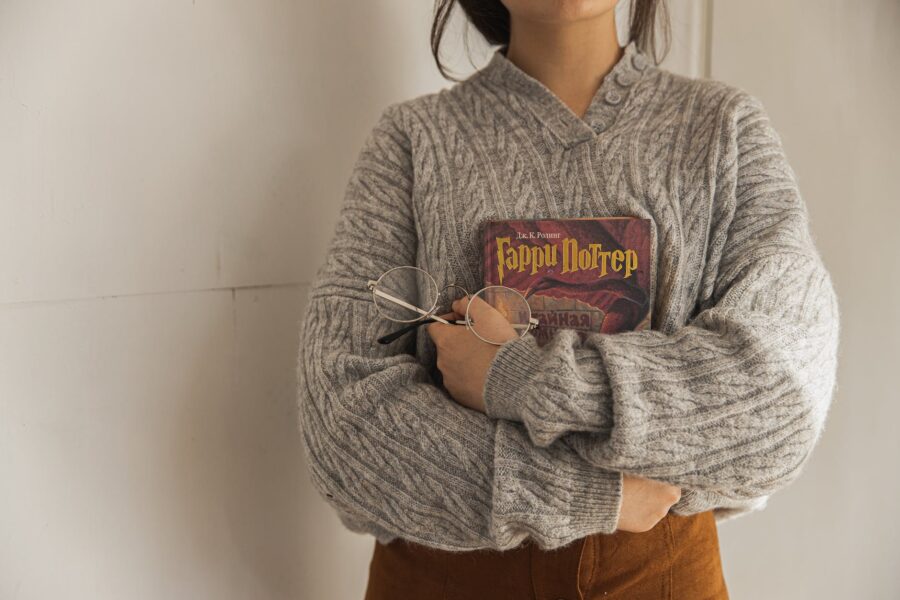 srtetnici, woman in gray sweater holding a book