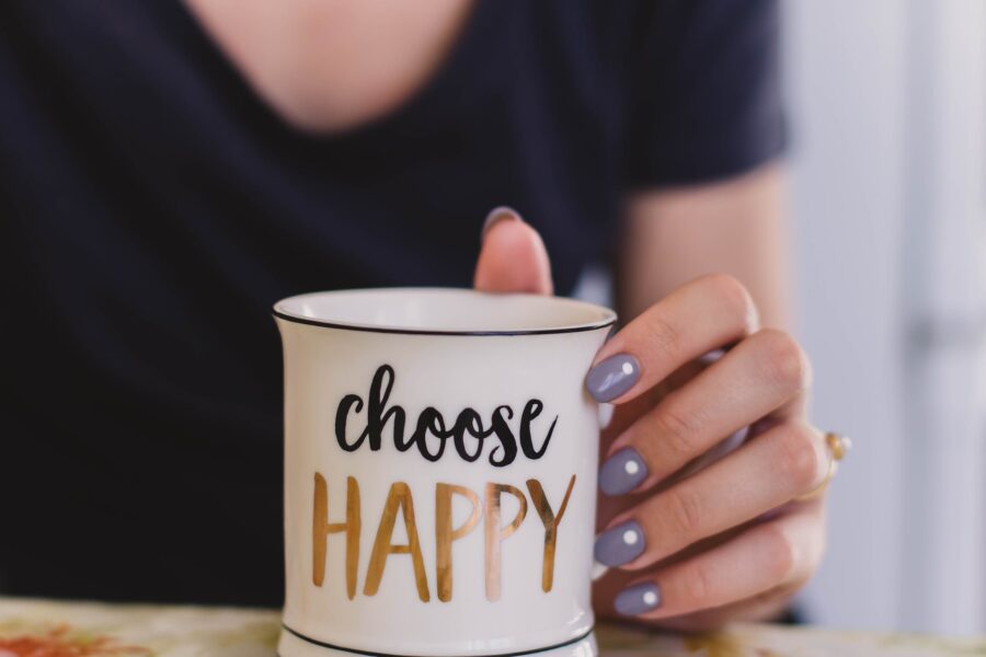 Mlad Mjesec u Vodenjaku donosi najveći sretnici ključni sastojak sreće granice, selective focus photography of person touch the white ceramic mug with choose happy graphic
